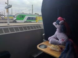 Size: 4128x3096 | Tagged: safe, derpibooru import, twilight sparkle, unicorn twilight, pony, unicorn, cake, crochet, food, irl, looking up, photo, plushie, poland, sitting, solo, train, train station, warsaw