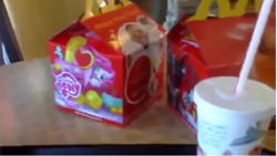 Size: 731x411 | Tagged: safe, derpibooru import, pinkie pie, 2012, bad quality, happy meal, irl, logo, mcdonald's, photo, soda, solo, table