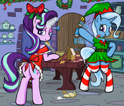 Size: 1670x1420 | Tagged: safe, artist:sallycars, derpibooru import, starlight glimmer, trixie, pony, unicorn, baking, bipedal, butt, christmas, clothes, cooking, dress, female, festive, gingerbread house, glowing horn, holiday, hoof hold, horn, looking at you, looking back, looking back at you, magic, mare, plot, socks, striped socks, telekinesis, tongue out, waving