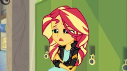 Size: 1100x618 | Tagged: safe, screencap, sunset shimmer, equestria girls, friendship games, clothes, hand on arm, hand on elbow, jacket, leather jacket, lockers, solo