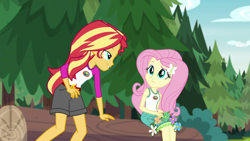 Size: 1280x720 | Tagged: safe, screencap, fluttershy, sunset shimmer, equestria girls, legend of everfree, clothes, embrace the magic, flower, lidded eyes, log, shorts, sun, tree