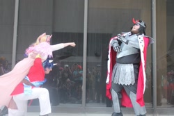 Size: 960x640 | Tagged: safe, artist:farondk, artist:sanora, king sombra, princess cadance, shining armor, human, convention, cosplay, epic wife tossing, fastball special, irl, irl human, momocon, photo