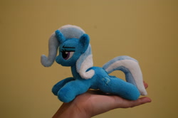 Size: 3008x2000 | Tagged: safe, artist:lanacraft, derpibooru import, trixie, human, pony, unicorn, hand, in goliath's palm, irl, kittensized, lidded eyes, photo, plushie, prone, smiling