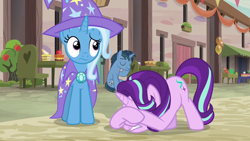 Size: 1280x720 | Tagged: safe, derpibooru import, screencap, starlight glimmer, trixie, pony, unicorn, to where and back again, cape, clothes, eyes closed, face down ass up, hat, our town, raised eyebrow, sitting, trixie's cape, trixie's hat, wavy mouth