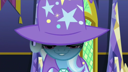 Size: 1280x720 | Tagged: safe, derpibooru import, screencap, trixie, no second prances, cape, clothes, evil grin, grin, hat, smiling, smirk, solo, trixie's cape, trixie's glare, trixie's hat