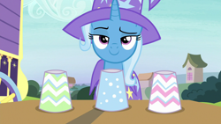 Size: 1280x720 | Tagged: safe, derpibooru import, screencap, trixie, uncommon bond, clothes, cup, hat, smug, solo, trixie's hat, trixie's wagon