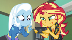 Size: 1280x720 | Tagged: safe, derpibooru import, edit, edited screencap, screencap, sunset shimmer, trixie, better together, equestria girls, forgotten friendship, clothes, discovery family logo, duo, female, nintendo switch, tongue out