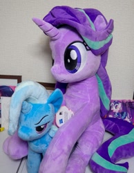 Size: 929x1200 | Tagged: safe, artist:nekokevin, derpibooru import, starlight glimmer, trixie, pony, unicorn, series:nekokevin's glimmy, 4de, duo, female, irl, mare, narrowed eyes, photo, plushie, sitting, size difference, smiling, table