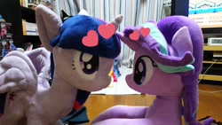 Size: 1200x675 | Tagged: safe, artist:nekokevin, derpibooru import, starlight glimmer, trixie, twilight sparkle, twilight sparkle (alicorn), alicorn, pony, unicorn, series:nekokevin's glimmy, duo, female, heart, irl, looking at each other, mare, photo, plushie, sitting, smiling, television