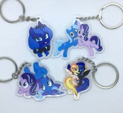 Size: 713x652 | Tagged: safe, derpibooru import, daybreaker, nightmare moon, princess luna, starlight glimmer, trixie, alicorn, pony, unicorn, a royal problem, road to friendship, to change a changeling, bow, cape, clothes, cute, hat, irl, keychain, photo, tongue out, trixie's cape, trixie's hat