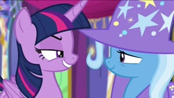 Size: 1136x640 | Tagged: safe, derpibooru import, screencap, trixie, twilight sparkle, twilight sparkle (alicorn), alicorn, pony, unicorn, no second prances, cape, clothes, duo, fake smile, female, folded wings, forced smile, grin, hat, lidded eyes, long time no see, mare, narrowed eyes, rivalry, smiling, suspicious, trixie's cape, trixie's hat, twilight's castle, wings