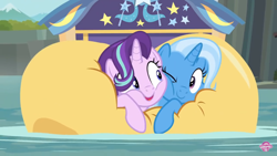 Size: 1334x750 | Tagged: safe, derpibooru import, screencap, starlight glimmer, trixie, pony, unicorn, road to friendship, cheek squish, cheek to cheek, cute, diatrixes, duo, eye contact, female, friendshipping, ghastly gorge, glimmerbetes, i guess we're stuck together, inflatable, inflatable raft, looking at each other, mare, one eye closed, pinned, prone, raft, river, shipping fuel, snuggling, squished, squishy cheeks, trixie's wagon, wagon, water, we're friendship bound