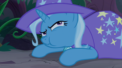 Size: 1280x720 | Tagged: safe, derpibooru import, screencap, trixie, pony, unicorn, student counsel, cape, chewing, clothes, eating, female, forest, hat, mare, munching, nose wrinkle, prone, solo, trixie's cape, trixie's hat