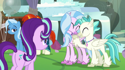 Size: 1920x1080 | Tagged: safe, derpibooru import, screencap, mudbriar, silverstream, starlight glimmer, sunburst, terramar, trixie, classical hippogriff, hippogriff, pony, unicorn, student counsel, balloon, brother and sister, butt, cute, diastreamies, eyes closed, female, folded wings, hug, jewelry, male, mare, necklace, plot, siblings, smiling, stallion, terrabetes, tree, wings