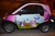 Size: 900x600 | Tagged: safe, princess cadance, shining armor, alicorn, pony, unicorn, car, channel, female, irl, male, mare, my little pony logo, night, photo, smart (car), smart fortwo, stallion, tiji