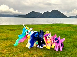 Size: 1200x888 | Tagged: safe, artist:nekokevin, princess cadance, princess celestia, princess luna, twilight sparkle, twilight sparkle (alicorn), alicorn, pony, unicorn, alicorn tetrarchy, cloud, crown, female, hoof shoes, irl, lake, mare, nature, peytral, photo, plushie, regalia, size difference, smiling, spread wings, wings