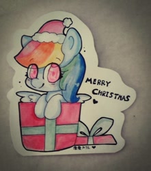 Size: 847x960 | Tagged: safe, artist:moonarty, derpibooru import, rainbow dash, pony, box, chibi, christmas, cute, dashabetes, happy, hat, irl, looking at you, photo, pony in a box, present, santa hat, solo, traditional art