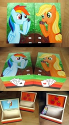 Size: 1000x1812 | Tagged: safe, artist:atelok, derpibooru import, applejack, rainbow dash, earth pony, pegasus, pony, box, card, cutie mark, photo, table