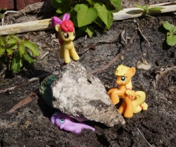 Size: 891x750 | Tagged: safe, apple bloom, applejack, diamond tiara, abuse, blind bag, boulder, crushing, imminent death, irl, murder, outdoors, photo, rock, tiarabuse, toy, witch trials