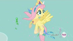 Size: 1450x816 | Tagged: safe, screencap, fluttershy, pegasus, pony, testing testing 1-2-3, celestia costume, celestia's crown, clothes, costume, crown, fake horn, female, flying, grin, hub logo, jewelry, mare, peytral, regalia, shylestia, smiling, solo