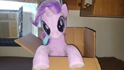 Size: 1200x675 | Tagged: safe, artist:nekokevin, starlight glimmer, pony, unicorn, series:nekokevin's glimmy, box, female, irl, looking at you, mare, photo, plushie, pony in a box, raised hoof, smiling, solo, underhoof