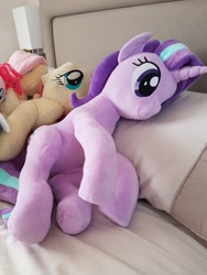Size: 900x1200 | Tagged: safe, artist:nekokevin, fluttershy, pinkie pie, starlight glimmer, pony, unicorn, series:nekokevin's glimmy, bed, female, irl, lying down, mare, photo, pillow, plushie, size difference, smiling, underhoof