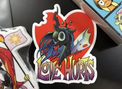 Size: 2048x1490 | Tagged: safe, artist:andypriceart, queen chrysalis, changeling, changeling queen, bronycon, evil grin, female, grin, heart, looking at you, smiling, sticker