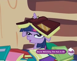 Size: 945x761 | Tagged: safe, derpibooru import, screencap, twilight sparkle, pony, unicorn, secret of my excess, book, book hat, derp, floppy ears, golden oaks library, horn impalement, hub logo, open mouth, reaction image, solo