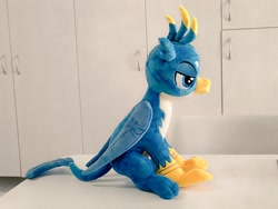 Size: 1024x768 | Tagged: safe, artist:nekokevin, gallus, griffon, folded wings, irl, lidded eyes, male, photo, plushie, side view, sitting, smiling, solo, teenager, wings