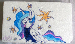 Size: 1000x596 | Tagged: safe, artist:raininess, princess celestia, alicorn, pony, clothes, shirt, sitting, smiling, solo, styrofoam, traditional art, wink