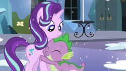 Size: 1280x720 | Tagged: safe, screencap, spike, starlight glimmer, dragon, pony, unicorn, the crystalling, adorable face, cute, cute smile, daaaaaaaaaaaw, eyes closed, female, hug, mare, shipping fuel, smiling, snow, spikelove, table