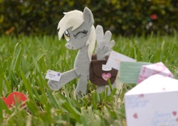 Size: 1500x1066 | Tagged: safe, artist:foxxy-arts, derpy hooves, pegasus, pony, craft, derpy day, derpy day 2012, felt, grass, holding, irl, letter, mailmare, one eye closed, photo, ponies in real life, saddle bag, solo, spread wings, traditional art, wings, wink
