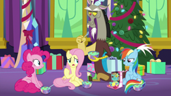 Size: 1280x720 | Tagged: safe, derpibooru import, screencap, discord, fluttershy, pinkie pie, rainbow dash, draconequus, earth pony, pegasus, pony, best gift ever, bowl, female, food, hearth's warming tree, holly the hearths warmer doll, mare, present, pudding, puddinghead's pudding, sitting, spoon, tree