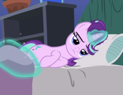 Size: 582x455 | Tagged: safe, screencap, starlight glimmer, pony, unicorn, rock solid friendship, bed, blanket, cropped, female, glowing horn, horn, levitation, lidded eyes, lying down, magic, mare, pillow, solo, starlight is not amused, telekinesis, unamused