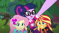 Size: 1280x720 | Tagged: safe, screencap, fluttershy, sci-twi, sunset shimmer, twilight sparkle, better together, equestria girls, festival filters, bigfoot, bigfoot blurry in the background, female, geode of telekinesis, magical geodes, peace sign, sasquatch, selfie, smiling