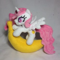 Size: 960x960 | Tagged: safe, artist:burgunzik, princess celestia, banana, bananalestia, cewestia, cute, filly, food, irl, photo, pink-mane celestia, plushie, solo, spread wings