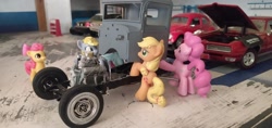 Size: 3264x1546 | Tagged: safe, apple bloom, applejack, derpy hooves, pinkie pie, rainbow dash, earth pony, pegasus, pony, blind bag, chassis, chevrolet impala, engine, everfree customs, ford crown victoria police interceptor, garage, pontiac gto, toy, volkswagen beetle