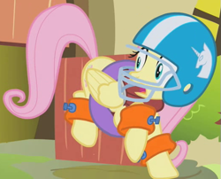 Size: 523x423 | Tagged: safe, screencap, fluttershy, pegasus, pony, dragonshy, american football, cropped, female, floatie, folded wings, football helmet, helmet, inner tube, mare, outfit catalog, solo, startled, wings