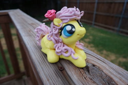 Size: 1024x680 | Tagged: safe, artist:sculpedetails, fluttershy, figure, flower, flower in hair, folded wings, irl, looking up, lying, photo, rose, sculpture, solo