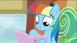 Size: 1280x720 | Tagged: safe, derpibooru import, screencap, rainbow dash, pegasus, pony, the lost treasure of griffonstone, alternate hairstyle, book, discovery family logo, fake smile, female, hoof hold, imitation, looking down, manebow sparkle, manual, multicolored mane, reading, solo, train