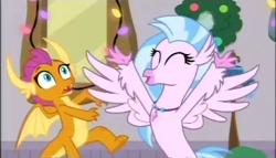 Size: 630x360 | Tagged: safe, screencap, silverstream, smolder, classical hippogriff, dragon, hippogriff, the hearth's warming club, dragoness, duo, female, hearth's warming, jewelry, necklace, spread wings, wings