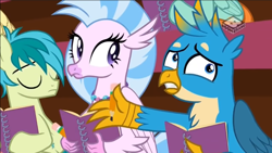 Size: 1066x600 | Tagged: safe, screencap, gallus, sandbar, silverstream, earth pony, griffon, hippogriff, pony, the end in friend, boomerang (tv channel), confused, eyes closed, female, male, notebook, notepad, pencil, teenager, trio, youtube link