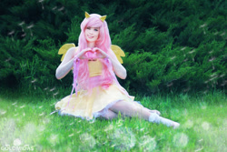 Size: 1280x853 | Tagged: safe, artist:tinemarieriis, fluttershy, human, clothes, cosplay, costume, heart hands, irl, irl human, one eye closed, photo, sitting, smiling, solo, wink