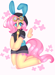 Size: 2483x3400 | Tagged: safe, artist:bunxl, fluttershy, pegasus, pony, semi-anthro, anatomically incorrect, blushing, bunny ears, clothes, colored pupils, costume, cute, cutie mark background, dangerous mission outfit, female, goggles, heart, heart eyes, hoodie, incorrect leg anatomy, kneeling, looking at you, mare, signature, simple background, smiling, solo, white background, wingding eyes