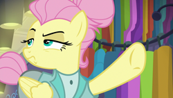 Size: 1280x720 | Tagged: safe, screencap, fluttershy, pegasus, pony, fake it 'til you make it, alter ego, alternate hairstyle, clothes, female, folded wings, hair bun, lidded eyes, manehattan, mare, pointing, raised eyebrow, raised hoof, rarity for you, severeshy, solo, tail bun, underhoof, wings