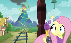 Size: 1775x1080 | Tagged: safe, screencap, fluttershy, pegasus, pony, dungeons and discords, clothes, earmuffs, female, looking back, mare, ponyville, solo, train, train tracks, volcano
