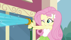 Size: 1912x1072 | Tagged: safe, screencap, fluttershy, dance magic, equestria girls, spoiler:eqg specials, bubble, canterlot high, car wash, clothes, cute, eyeshadow, female, grin, hose, makeup, one eye closed, shyabetes, skirt, sleeveless, smiling, solo, tanktop, this will end in wet tshirts, water, wink