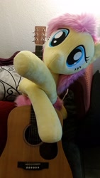 Size: 1836x3264 | Tagged: safe, artist:joltage, fluttershy, pegasus, pony, acoustic guitar, cute, female, guitar, happy, irl, musical instrument, photo, pillow, plushie, smiling, solo