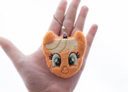 Size: 1000x718 | Tagged: safe, artist:meplushyou, applejack, earth pony, human, pony, charm, female, freckles, hand, irl, irl human, looking at you, mare, photo, plushie, smiling