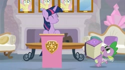 Size: 1654x927 | Tagged: safe, derpibooru import, screencap, fluttershy, spike, twilight sparkle, twilight sparkle (alicorn), alicorn, dragon, pegasus, pony, non-compete clause, book, fireplace, sofa, wall of shy